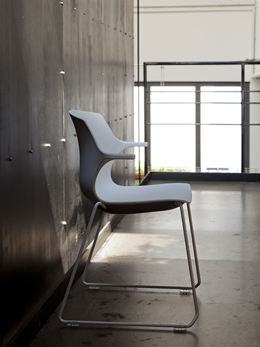 Seduta FRILL con telaio a slitta disponibile cromato o con struttura verniciata nera o bianca. Scocca in polipropilene con braccioli integrati.